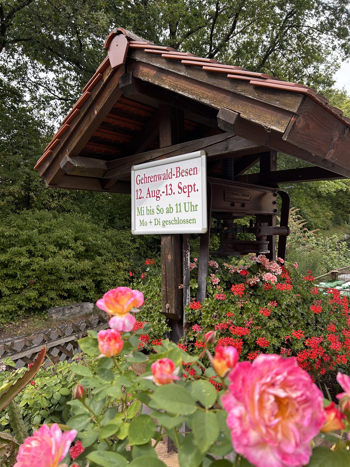 Das handgemalte Schild mit den Besen-Terminen an der alten Weinpresse