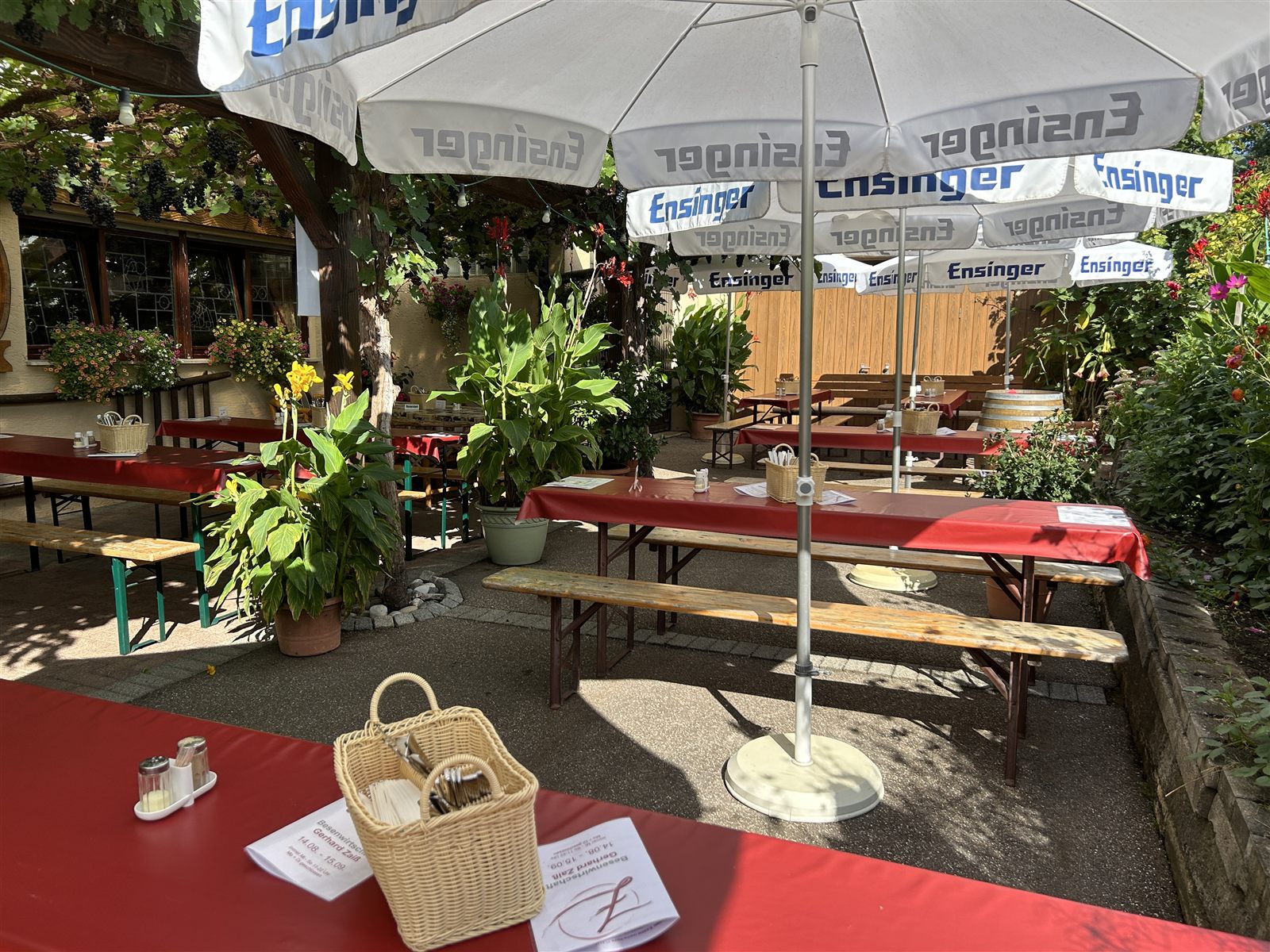 Gedeckter Tisch mit Besteckkorb unter dem Sonnenschirm